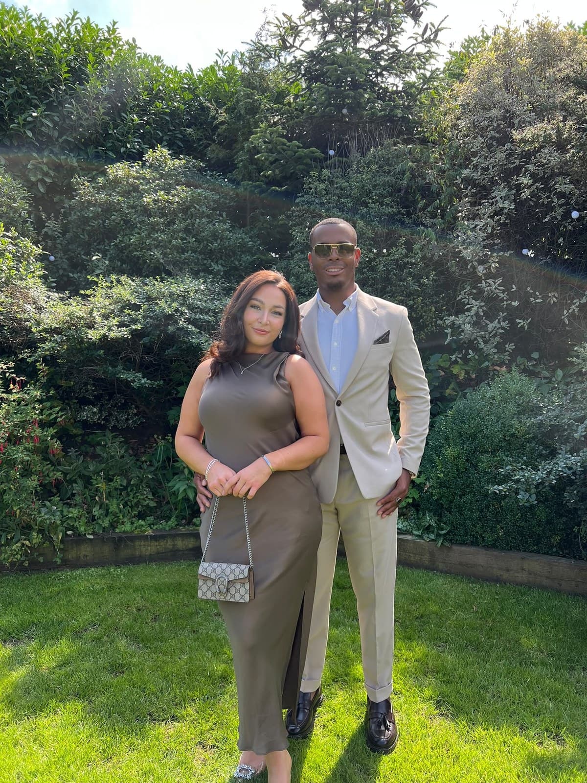 Georgia and Elijah in a garden, dressed up for an occasion