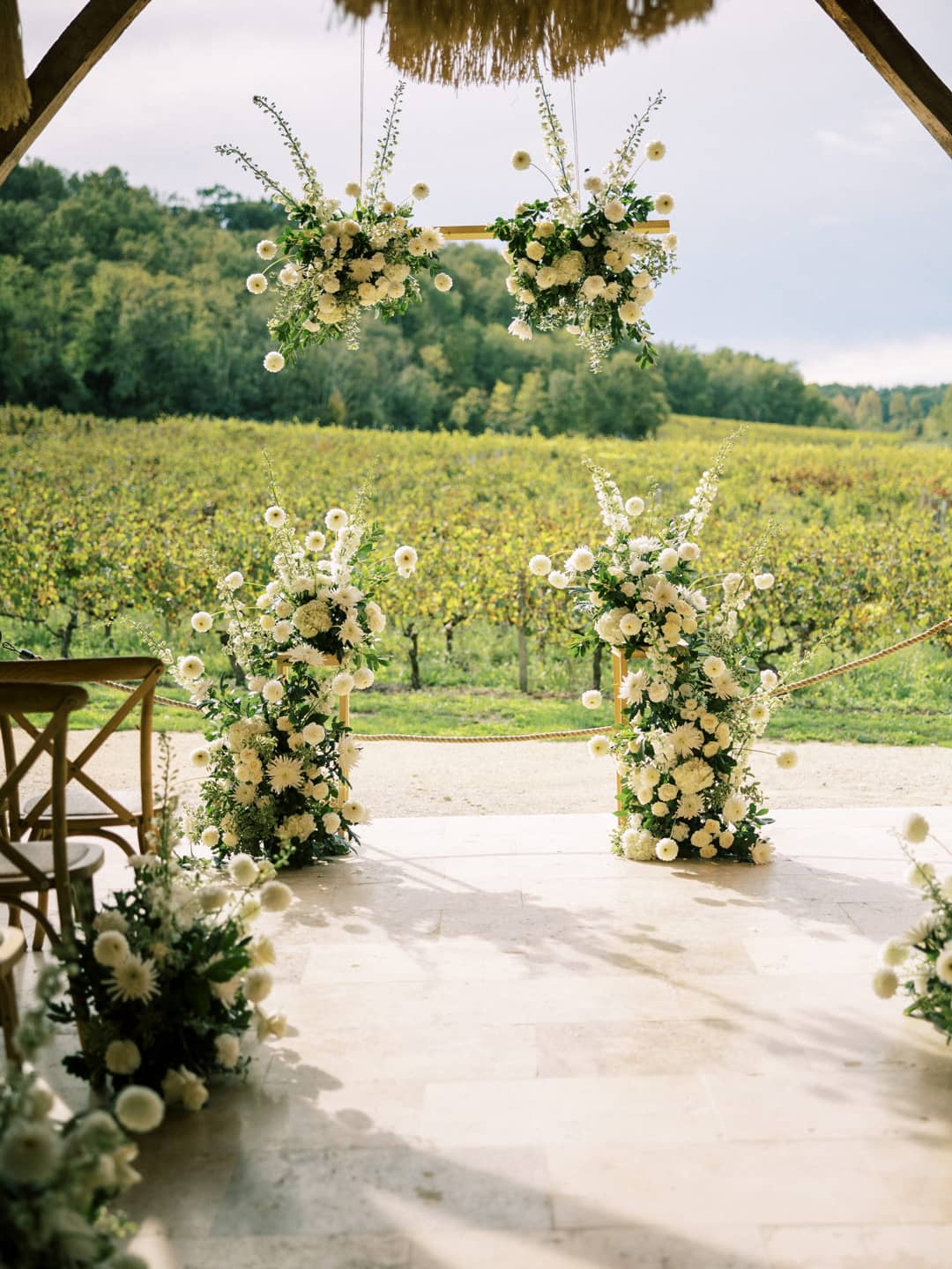 Floral arches on a stone terrace overlooking the vineyards